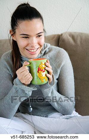 Teenage girl wtih a cup in the couch View Large Photo Image Stock Image - Teenage girl wtih a cup in the couch. Fotosearch