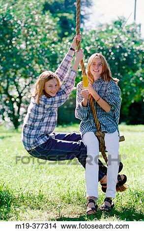 Picture - teenage girls on a rope swing. Fotosearch
