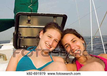 Teenage girls sitting on a sailboat View Large Photo Image Stock Photo - Teenage girls sitting on a sailboat. Fotosearch
