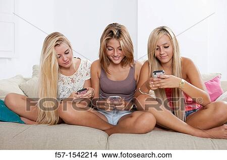 Teenage girls texting on their Blackberry? s View Large Photo Image Picture - Teenage girls texting on their Blackberry? s. Fotosearch