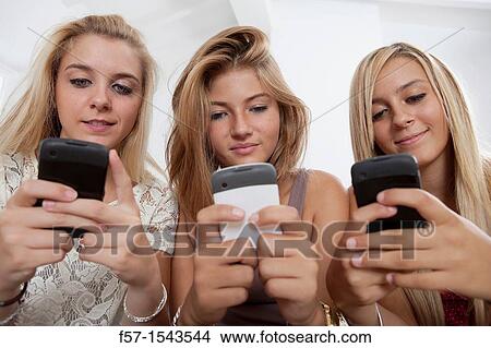 Teenage girls texting on their Blackberry? s View Large Photo Image Picture - Teenage girls texting on their Blackberry? s. Fotosearch