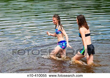 Teenage sisters, both in bathing suits, playing together at a lake in Connecticut, USA. View Large Photo Image Stock Photography - Teenage sisters, both in bathing suits, playing together at a lake in Connecticut, USA.. Fotosearch