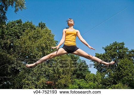 Teenaged girl jumping on a trampoline outdoors View Large Photo Image Stock Image - Teenaged girl jumping on a trampoline outdoors. Fotosearch