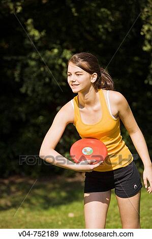 Stock Photo - Teenaged girl playing frisbee outdoors in a garden. Fotosearch