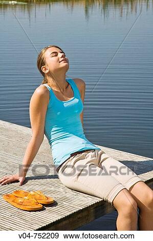 Teenaged girl relaxing and sunbathing at a lake View Large Photo Image Stock Photo - Teenaged girl relaxing and sunbathing at a lake. Fotosearch