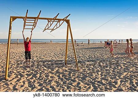 Stock Image - Teenager Boy Swinging on P? rnu Beach, Estonia. Fotosearch