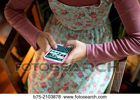 Teenager girl with a country flowers dress playing with a smart phone. View Large Photo Image Stock Photo - Teenager girl with a country flowers dress playing with a smart phone.. Fotosearch