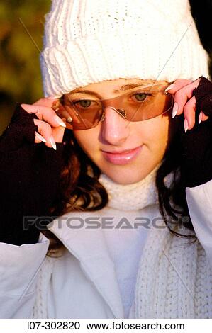 Teenager in white hat putting on sunglasses View Large Photo Image Stock Image - Teenager in white hat putting on sunglasses. Fotosearch