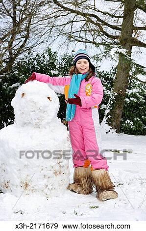 Stock Photo - teenager making a snowman, Senantes, Eure-et-Loir department, Centre region, France, Europe.. Fotosearch
