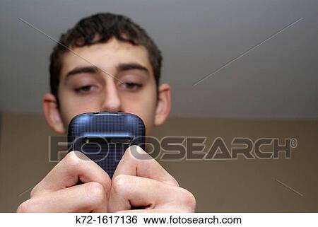 Teenager reading a text message View Large Photo Image Stock Photograph - Teenager reading a text message. Fotosearch