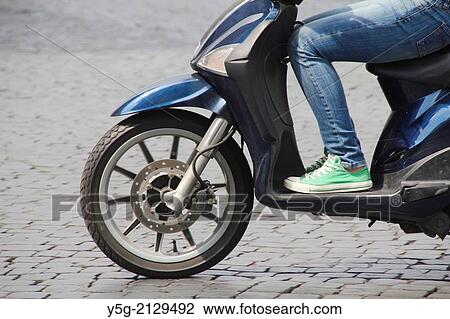 Stock Image - teenager riding scooter moped in rome italy. Fotosearch