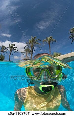 Stock Photo - teenager snorkels in hotel swimming pool - split shot, half and half. Fotosearch