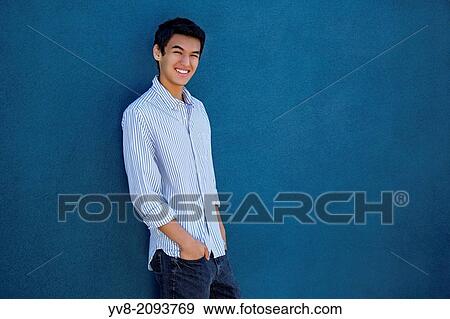 Teenager standing in front of a blue wall. View Large Photo Image Stock Photo - Teenager standing in front of a blue wall.. Fotosearch