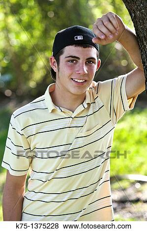 teenager standing next to tree View Large Photo Image Stock Photo - teenager standing next to tree. Fotosearch