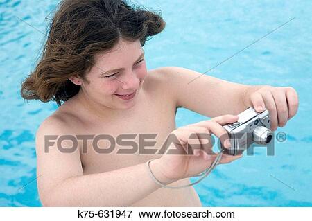Stock Photo - Teenager takes picture with digital camera.. Fotosearch