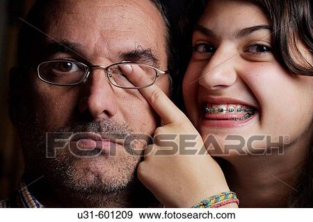 Teenager with brackets closes his dad's eye View Large Photo Image Stock Photo - Teenager with brackets closes his dad's eye. Fotosearch