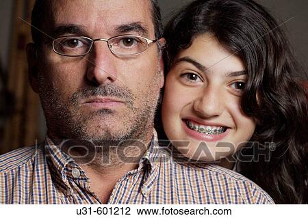 Teenager with brackets poses next to his angry looking dad View Large Photo Image Stock Image - Teenager with brackets poses next to his angry looking dad. Fotosearch