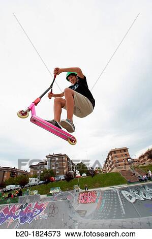 Stock Image - Teenager with city scooter in Skate park, Leioa, Bizkaia, Basque Country, Spain. Fotosearch