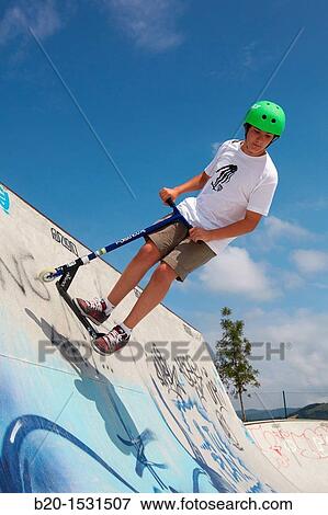 Stock Photo - Teenager with city scooter in Skate park, Irun, Gipuzkoa, Euskadi, Spain. Fotosearch