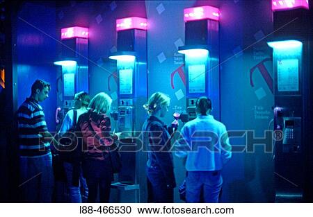 Stock Image - Teenagers at public phone, Germany. Fotosearch