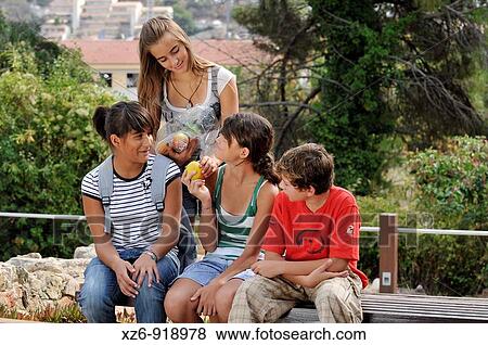 Stock Photo - Teenagers eating fruit. Fotosearch
