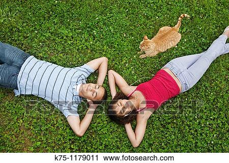 teenagers listening to music and relaxing with pet cat View Large Photo Image Stock Image - teenagers listening to music and relaxing with pet cat. Fotosearch