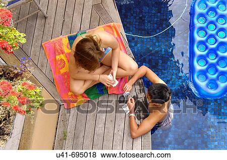 Stock Photo - Teenagers playing cards by the pool. Fotosearch