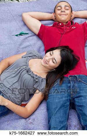 Teens listening to music on blanket View Large Photo Image Stock Photo - Teens listening to music on blanket. Fotosearch
