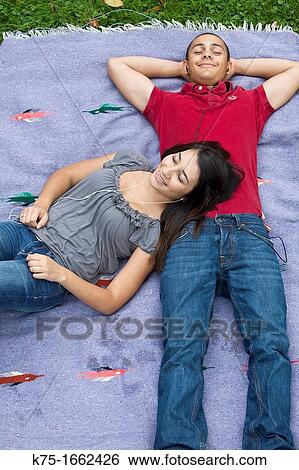 Teens listening to music outdoors on blanket View Large Photo Image Stock Photograph - Teens listening to music outdoors on blanket. Fotosearch