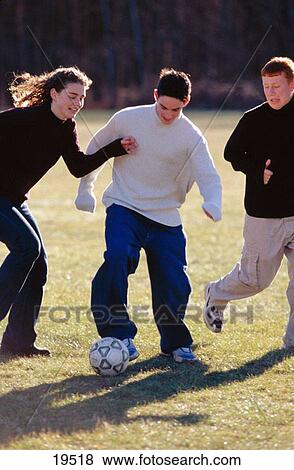 Stock Photo - Teens playing soccer. Fotosearch