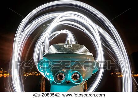 Stock Image - Telescope with light trails over an alpine lake maggiore in ticino switzerland.. Fotosearch
