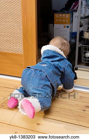 Stock Image - Ten Month Baby Girl Looking into Closet. Fotosearch