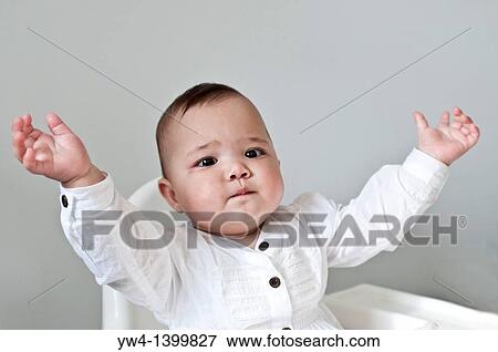 Stock Photo - Ten month old girl sitting in her high who has just learned to clap. Fotosearch