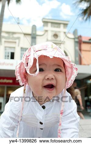 Stock Photograph - Ten month old girl with pink hat smiling. Fotosearch