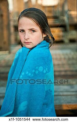 Ten year old girl wrapped in a blue towel after swimming in the sea, wet hair, looking at the camera View Large Photo Image Picture - Ten year old girl wrapped in a blue towel after swimming in the sea, wet hair, looking at the camera. Fotosearch