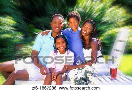Stock Photograph - Testimonial African American family relaxing at home outdoors. Fotosearch