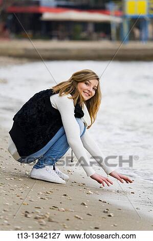 Testing water young woman on the beach View Large Photo Image Stock Photo - Testing water young woman on the beach. Fotosearch