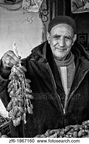 Stock Image - Testour in Tunisia Africa portrait of old Muslim man selling date in native dress. Fotosearch