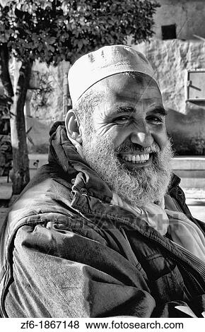 Stock Photo - Testour in Tunisia Africa smiling portrait of old Muslim man in native dress with beard. Fotosearch