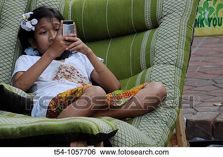 Thai Girl play with Phone View Large Photo Image Stock Photograph - Thai Girl play with Phone. Fotosearch