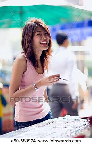 Thai woman (age 24) shopping in street market, Bangkok, Thailand View Large Photo Image Picture - Thai woman (age 24) shopping in street market, Bangkok, Thailand. Fotosearch