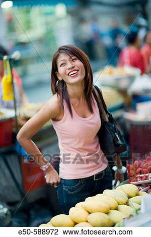 Stock Image - Thai woman (age 24) shopping in street market, Bangkok, Thailand. Fotosearch