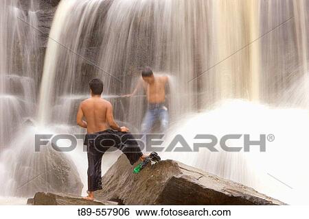 Thailand, Chaiyaphum. Tad Tone National Park, Tad Tone waterfall, Man sitting in the waterfall View Large Photo Image Stock Photograph - Thailand, Chaiyaphum. Tad Tone National Park, Tad Tone waterfall, Man sitting in the waterfall. Fotosearch