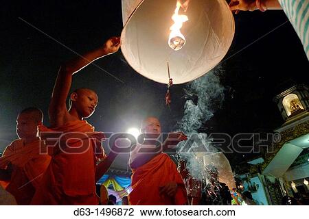 Stock Image - THAILAND Chiang Mai Loi Krathong lantern Festival Buddhist monks and tourists lighting and launching lanterns which float in the sky. Fotosearch