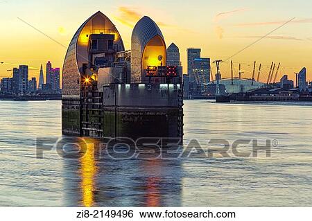 Stock Photograph - Thames Barrier at night, Canary Wharf and The Millennium Dome at night, London, England.. Fotosearch