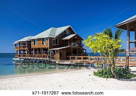 Stock Photo - The beach, pier, restaurants and boats at West End in Roatan, Honduras. Fotosearch