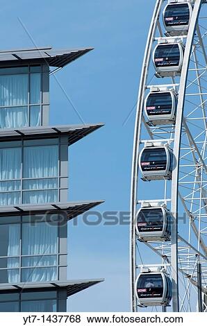 Stock Photo - The big ferris wheel at the Liverpool arena complex on the old docks next to apartment building Liverpool UK. Fotosearch