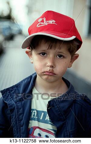 Stock Photo - The boy is sad because he ate all his ice cream. Fotosearch