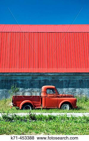 Stock Photo - The color of red in an old truck and barn roof near Isle de Ch? nes, Manitoba. Canada.. Fotosearch