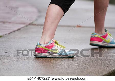 The colorful shoes of a young woman stretching before exercising View Large Photo Image Stock Photo - The colorful shoes of a young woman stretching before exercising. Fotosearch